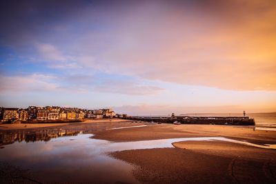 Scenic view of beach against sky during sunset