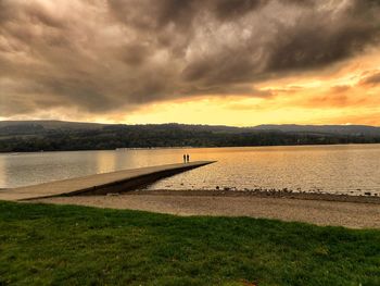 Scenic view of lake against cloudy sky