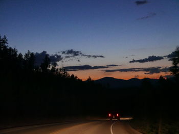 Cars on road against sky at night