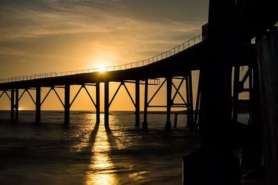 Bridge over river at sunset