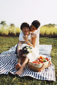 Mother and daughter in basket on field