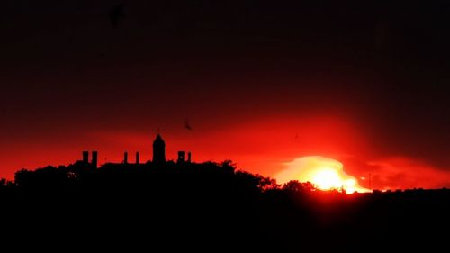 Silhouette building against sky during sunset