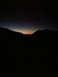 Silhouette mountain against sky at night