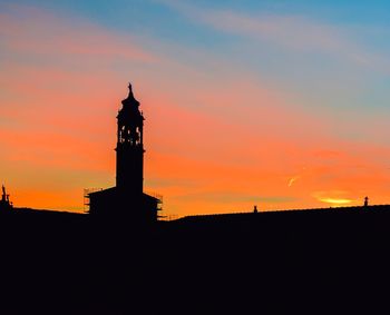 Silhouette of clock tower against sky during sunset