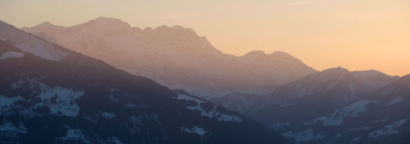 Scenic view of snowcapped mountains against sky during sunset