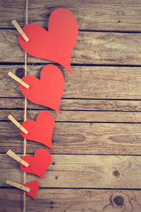 High angle view of red heart shape on wooden table