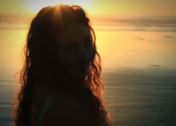 Woman looking at sea during sunset