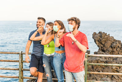People standing on beach against sky