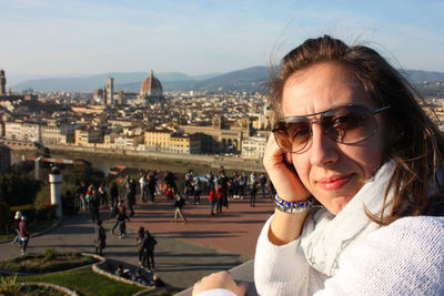 Portrait of beautiful woman in city against sky