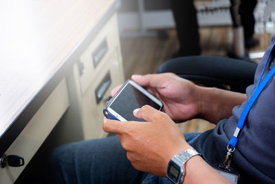 Midsection of man using mobile phone