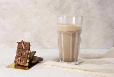 Delicious homemade cocoa drink with cocoa powder and pieces of chocolate bar.