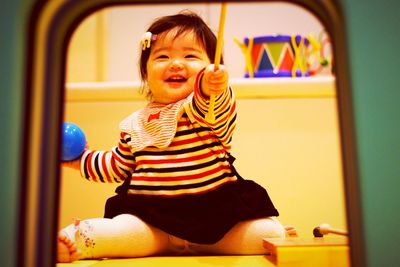 Portrait of smiling boy sitting in corridor