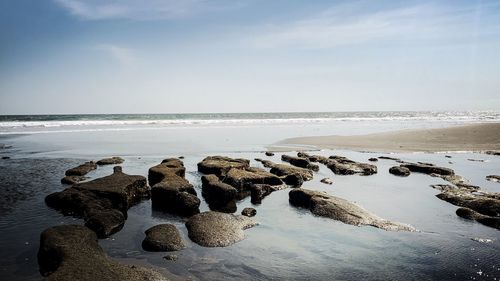 Rocks on beach against sky