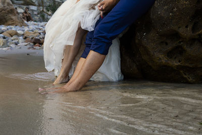 Side view of woman sitting on rock