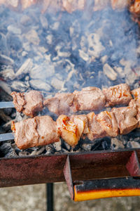 Closeup macro of raw roasted marinated meat barbecue shish kebab shashlik on steel metal skewers 