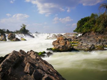Scenic view of waterfall against sky