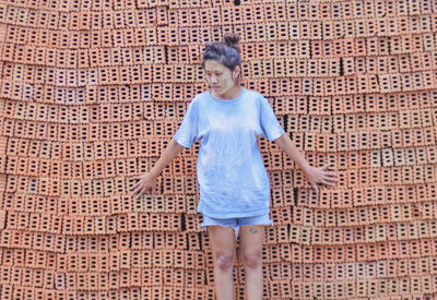 Full length of woman standing against wall