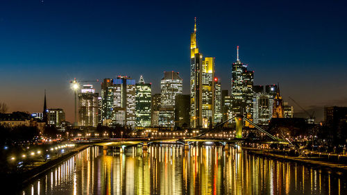 Illuminated cityscape against sky at night