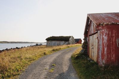 Houses by sea against clear sky