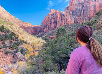 Rear view of woman walking on rock