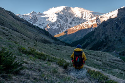 Rear view of person on snowcapped mountains