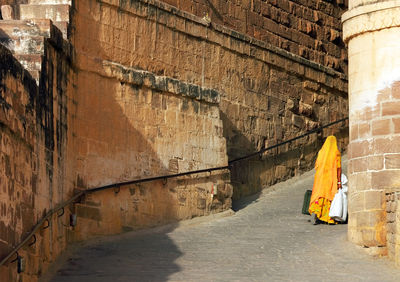 Wan walking on pathway along stone walls