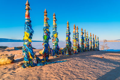 Multi colored umbrellas on beach against clear blue sky