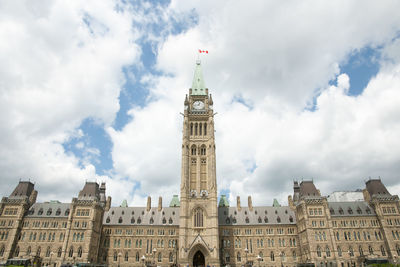 Low angle view of buildings against cloudy sky