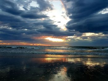 Scenic view of sea against dramatic sky during sunset