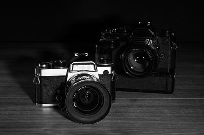 Close-up of cameras on table against black background