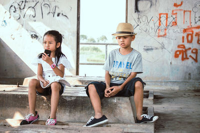 Full length of children sitting in park