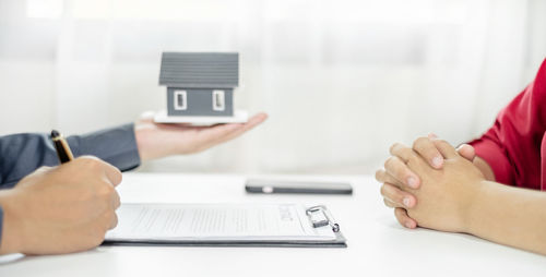 Cropped hands of man using mobile phone on table