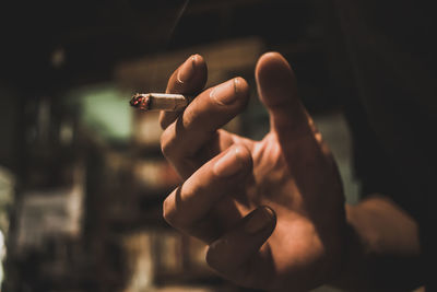 Close-up of hand holding cigarette