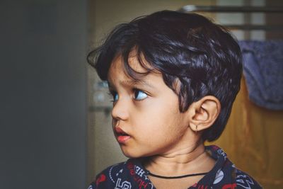 Close-up of boy looking away while at home