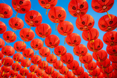 Low angle view of lantern hanging against red wall