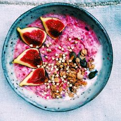 Directly above shot of breakfast bowl with figs and granola on table