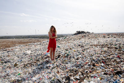 Full length of woman standing at beach against sky