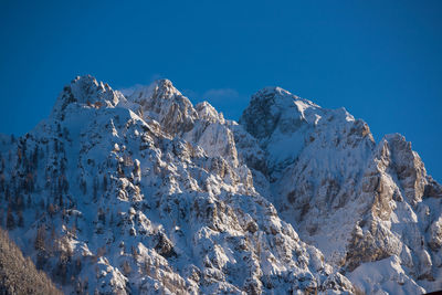 Scenic view of snowcapped mountains against clear blue sky