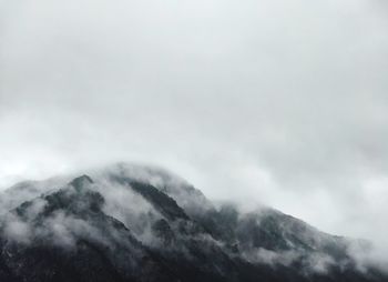 Low angle view of mountains against cloudy sky