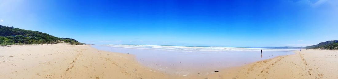Scenic view of beach against blue sky