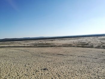 Scenic view of desert against clear blue sky