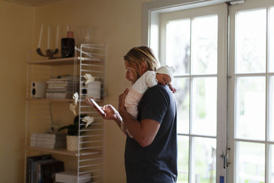 Rear view of couple holding hands at home