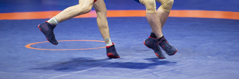 Low section of athletes wrestling on mat