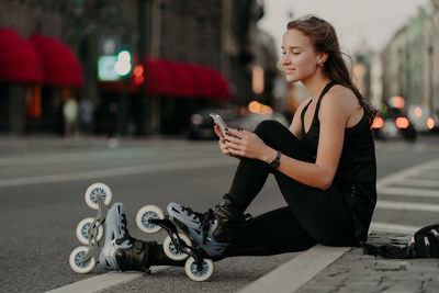 Side view of man using smart phone on street