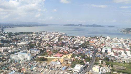 High angle view of townscape by sea against sky