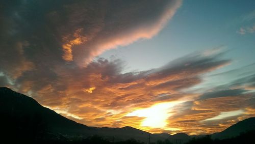 Low angle view of silhouette mountains against dramatic sky