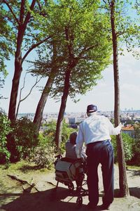 Rear view of woman sitting on tree