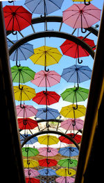 Low angle view of umbrellas hanging against sky