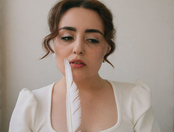 Portrait of young woman against wall