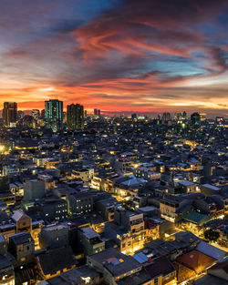 High angle view of illuminated cityscape against sky at sunset